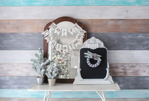 Neutral Christmas decor in entryway with wood plank wall.