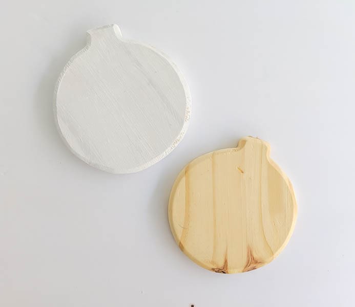 Two blank wooden ornaments - one raw wood and one painted white.