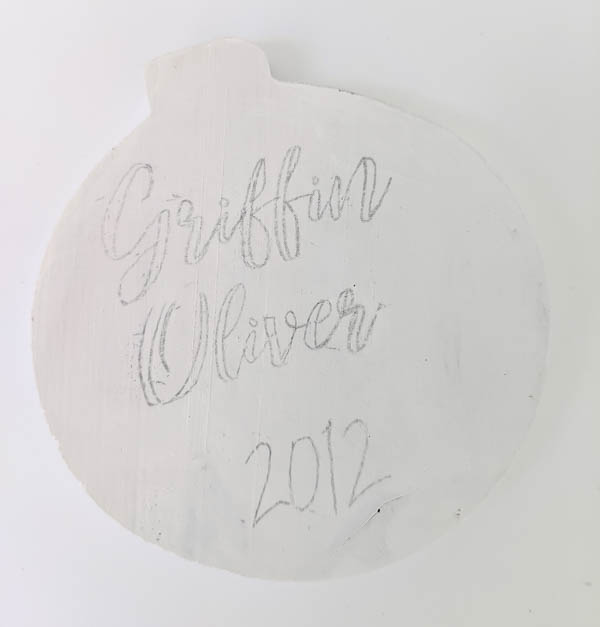 Wood ornament with name and date transferred onto it using pencil.