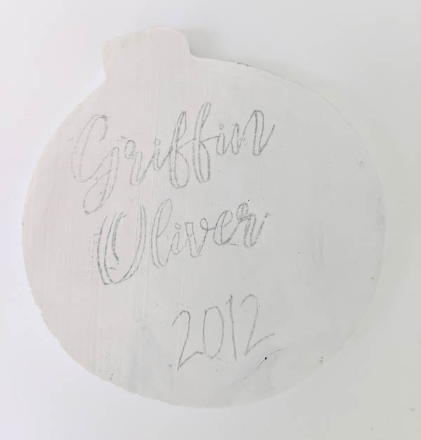 Wood ornament with name and date transferred onto it using pencil.