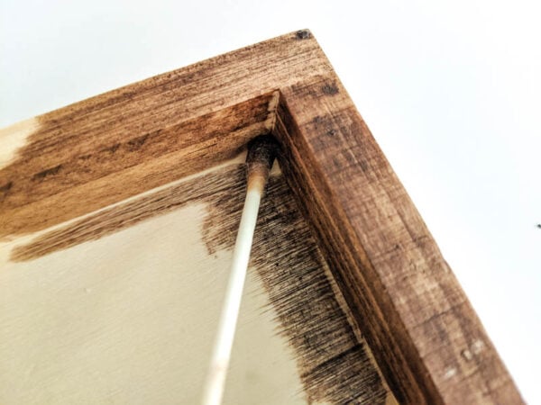 using a q-tip to get stain into the small interior corners of the frame.