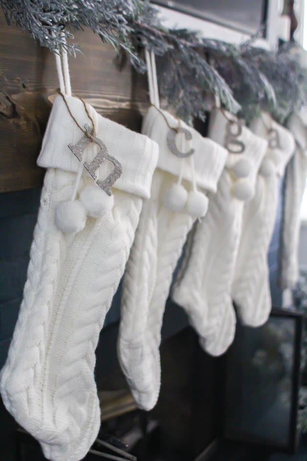 Simple white knit stockings with easy DIY stocking tags hung on fireplace.