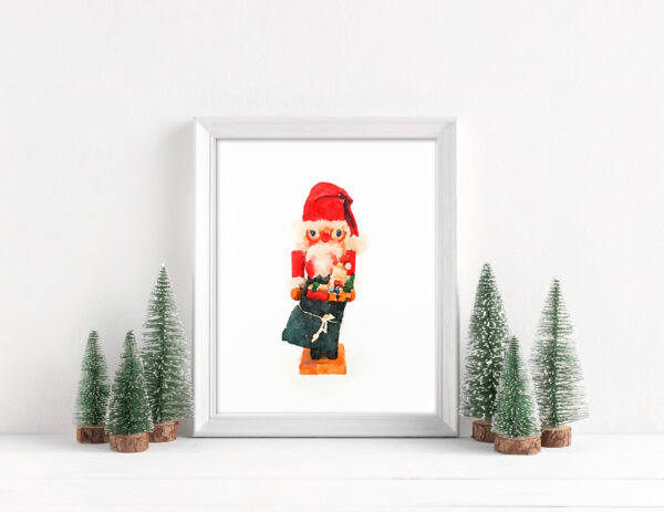 Framed Santa nutcracker art print surrounded by bottle brush Christmas trees. 