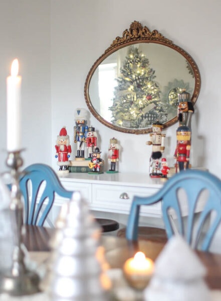 vintage nutcrackers on side table under antique mirror.