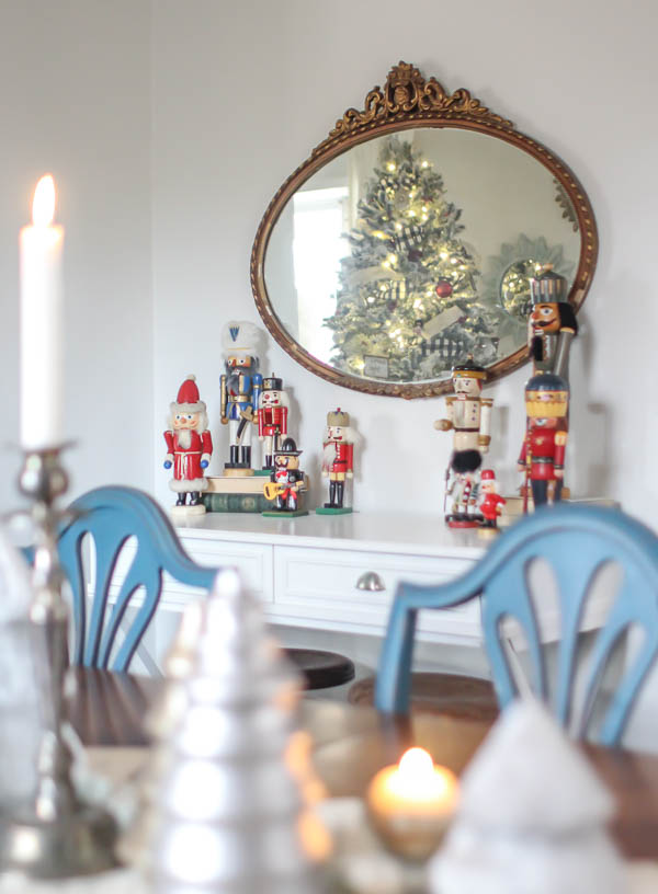 A collection of nutcrackers on a small table surrounded by other Christmas decor.