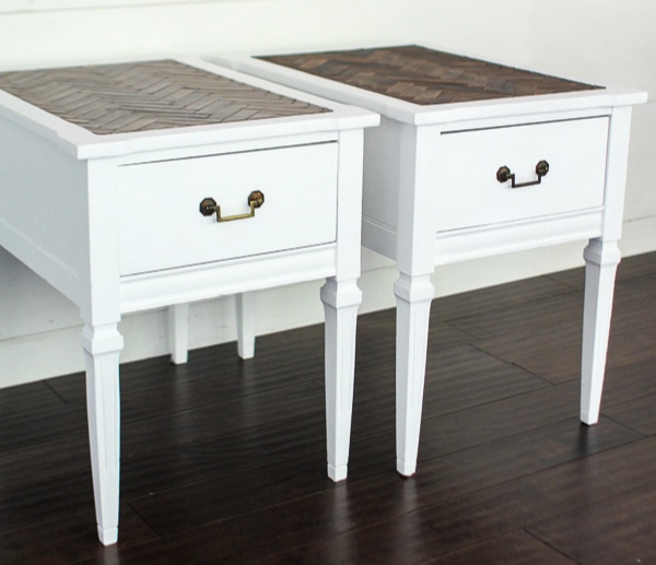 pair of wood end tables painted white.