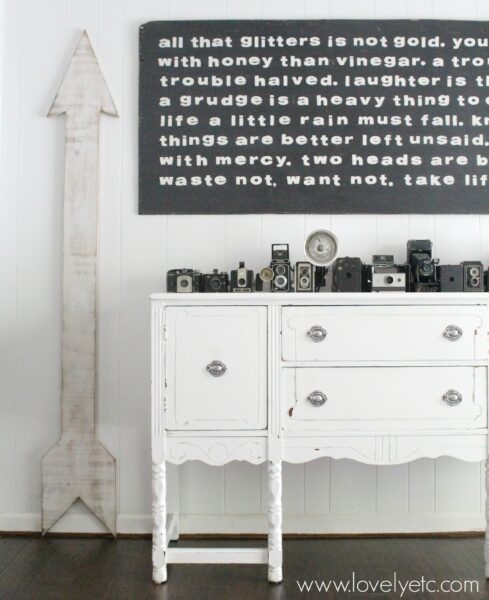 distressed white painted buffet with vintage cameras.