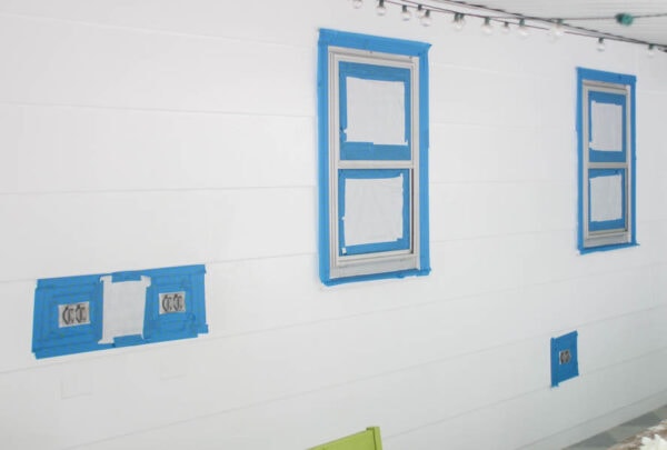 aluminum window frames and metal outlet covers surrounded by painter's tape