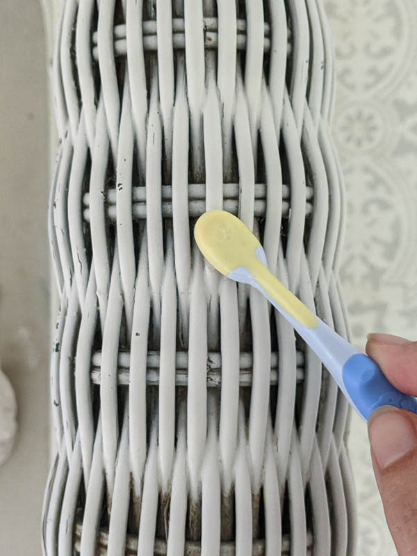 cleaning wicker furniture with an old toothbrush
