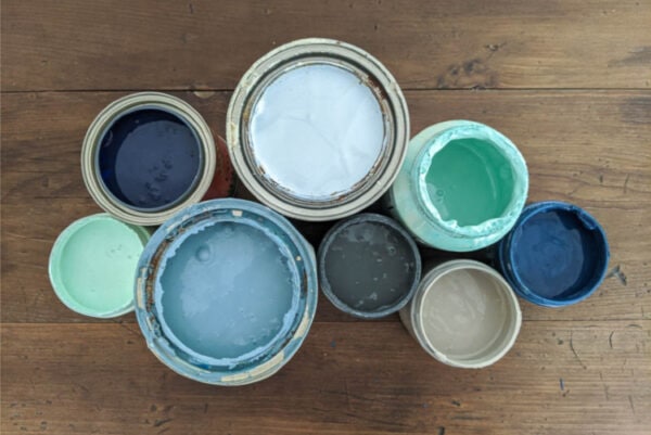 Eight different cans of furniture paint open to share the paint inside.