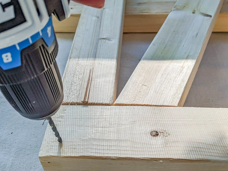 predrilling holes in side of daybed with drill.