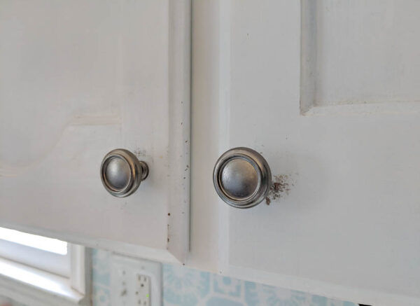 close up of chipped paint on white cabinets