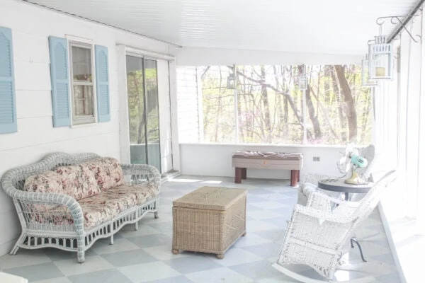 screened-in porch with painted checkerboard floor and wicker furniture