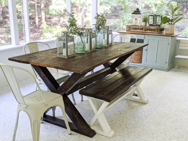 dark wood farmhouse table with wood bench and white bistro chairs on porch