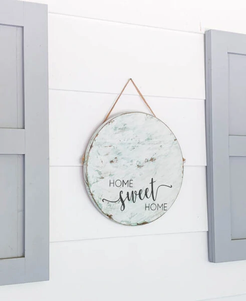 round home sweet home sign hanging on a white wall on the porch