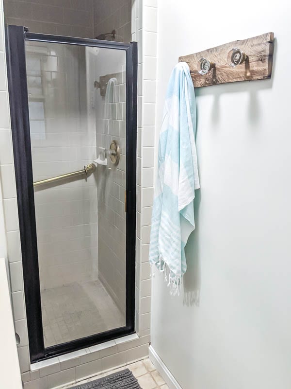 Gold shower door painted black and diy towel hooks made from vintage door knobs