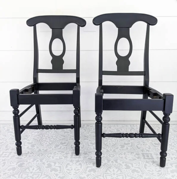 two wooden chairs with the seats removed painted black