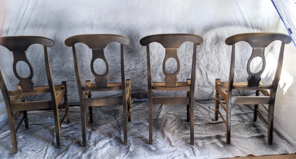 first coat of black paint on wooden chairs