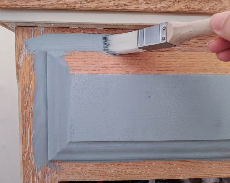 painting an oak vanity light blue using a paintbrush