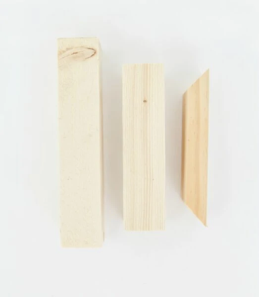 Three pieces of wood needed for diy shelf brackets - two rectangular pieces and a small trapezoid.