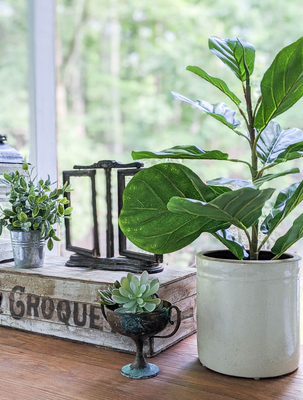 faux fiddle leaf fig and other faux plants on porch