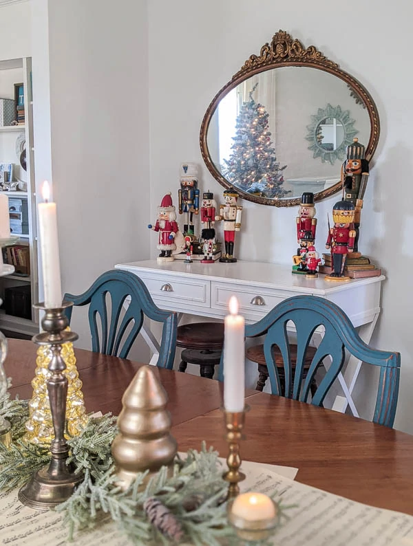 antique gold mirror hanging above white table with nutcracker collection