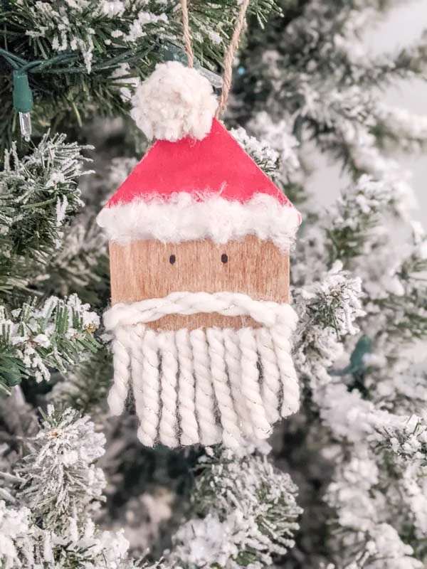 DIY wooden Santa ornament hanging on Christmas tree. 