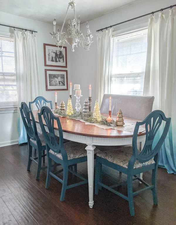 dining table with Christmas centerpiece made of candlesticks and glass Christmas trees