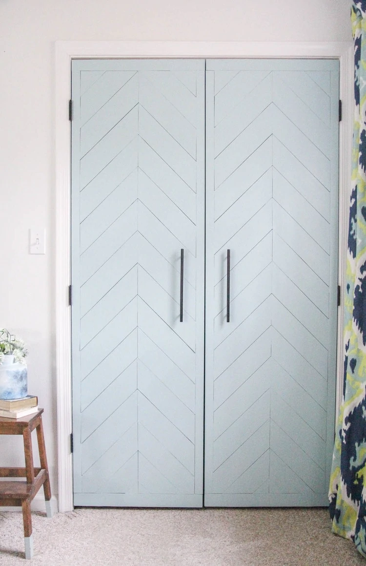 sliding closet door makeover with hinged doors, fresh paint, and a chevron wood pattern.