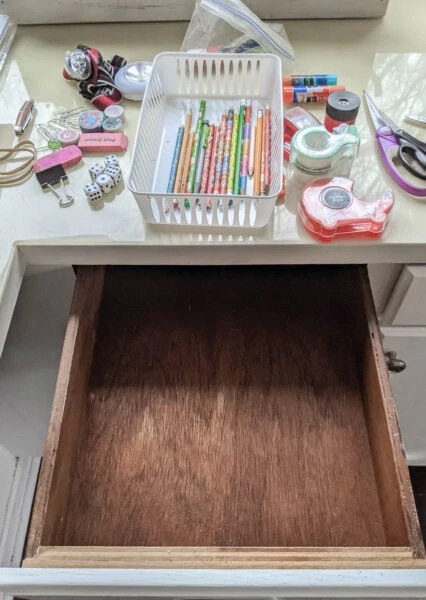 empty junk drawer with all the junk items on the counter above ready to sort.