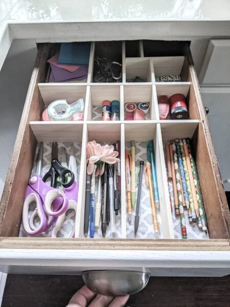 Junk drawer with new DIY wood drawer dividers corralling everything into neat sections.