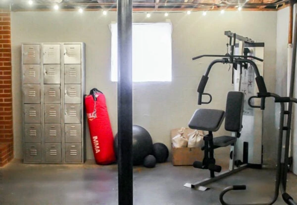 basement gym with punching bag, weights, and lockers.