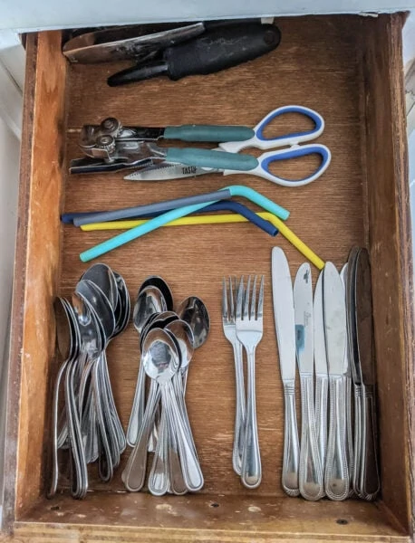 Silverware organized into piles in drawer to figure out drawer divider placement.