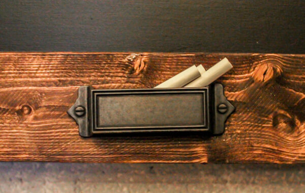 chalk holder on rustic diy chalkboard.