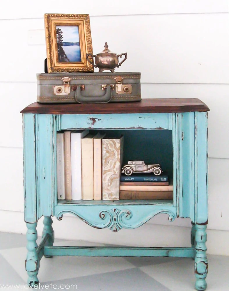 antique radio cabinet painted aqua with a wood top.
