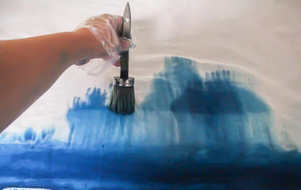 using a paintbrush to make ombre curtains.