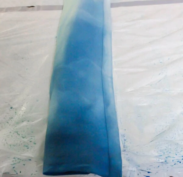 blue dyed curtains rolled up ready to go in a trash bag.