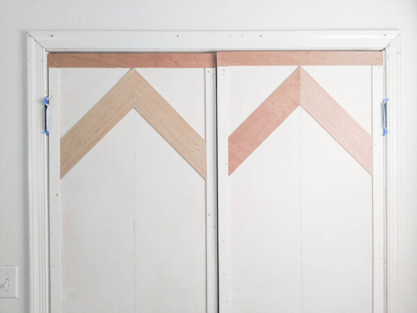 first row of chevron wood planks attached to door.