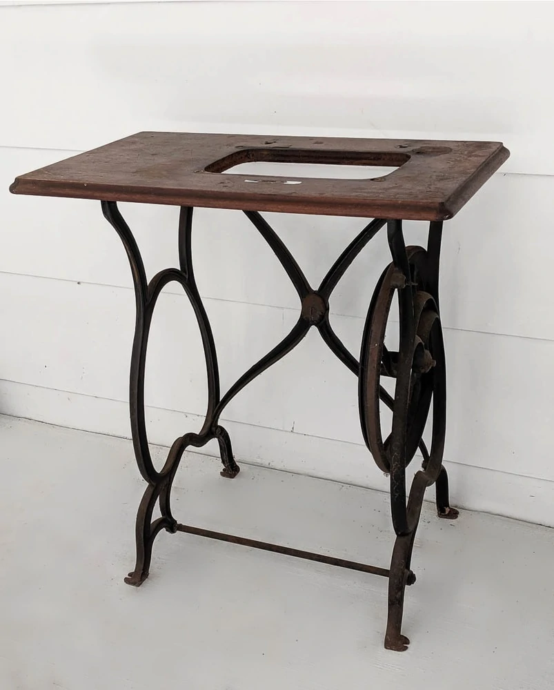 old sewing machine table with iron legs and no sewing machine.