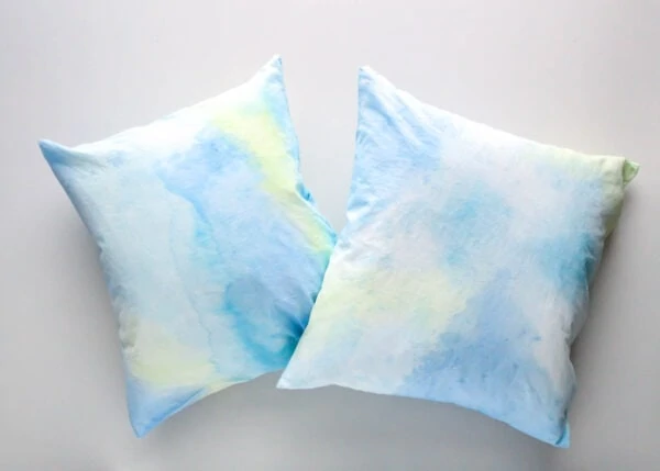 pair of painted pillows with blue and green watercolor abstract painting.