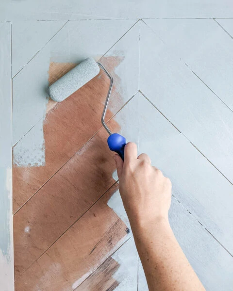 painting chevron wood plank doors with a small foam paint roller.