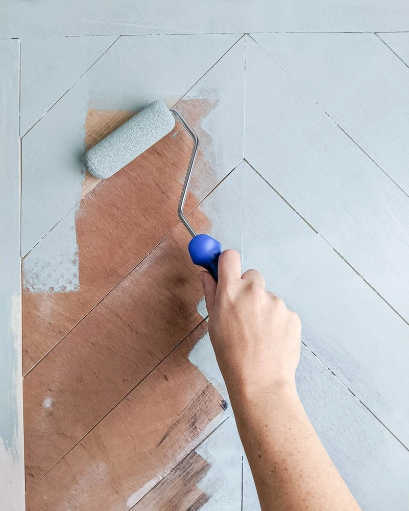 painting chevron wood plank doors with a small foam paint roller.