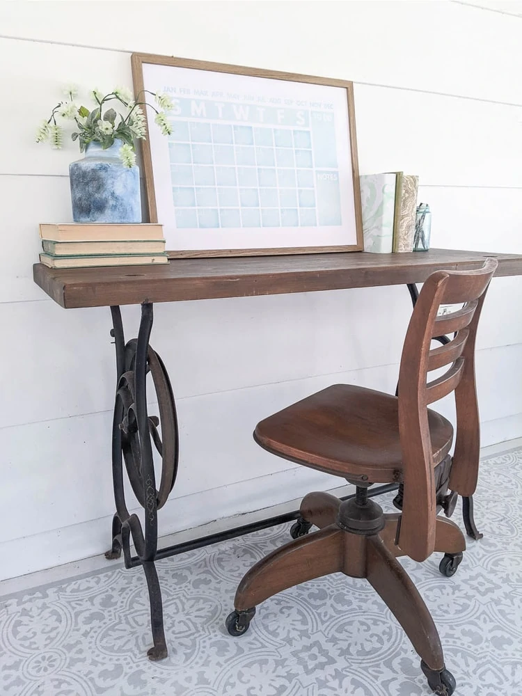 sewing machine table repurposed as a desk with a vintage wooden chair.
