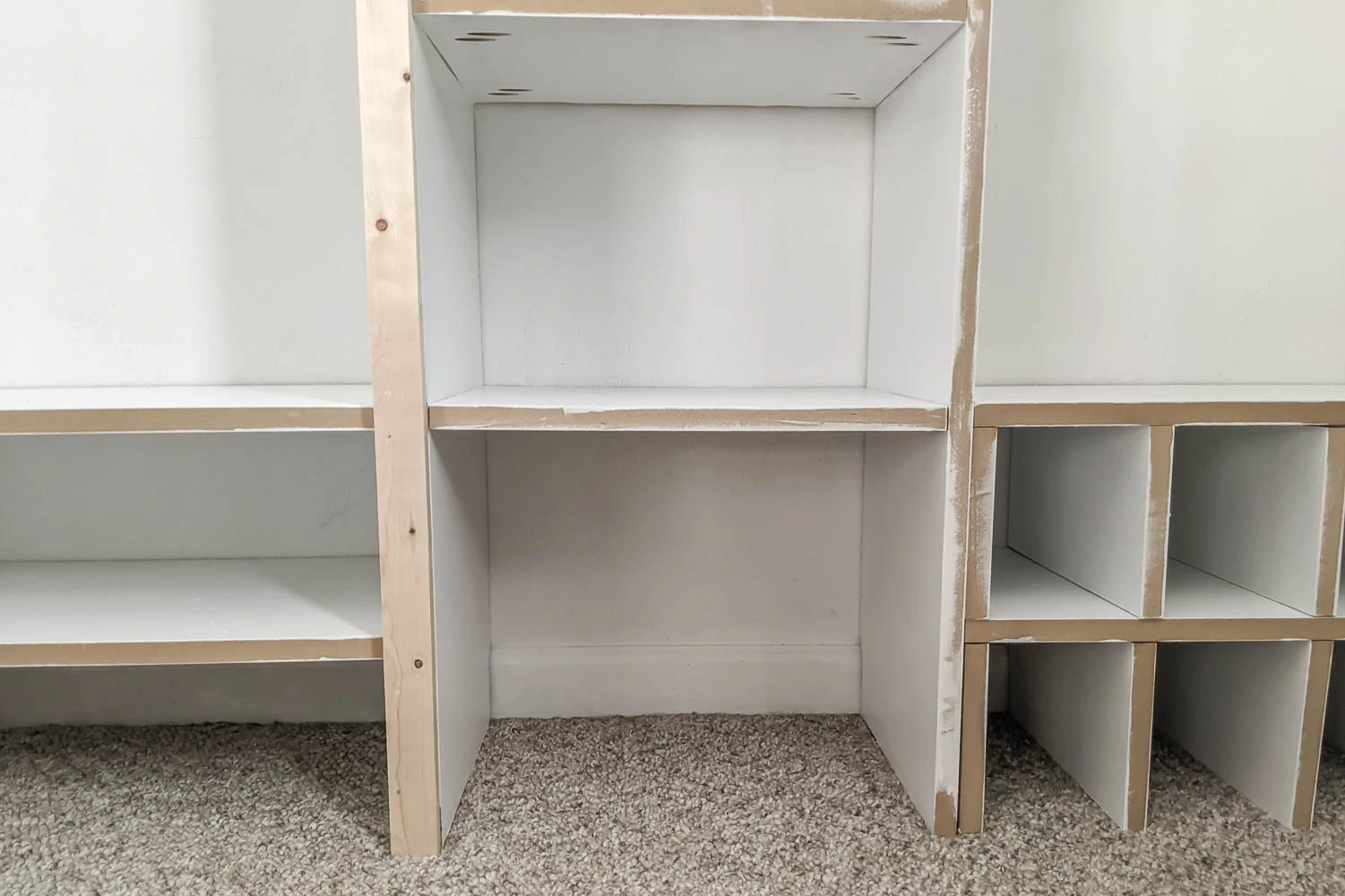 Adding trim to one side of the diy closet organizer.