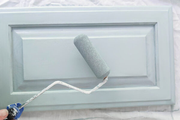 paint roller and cabinet door painted blue.