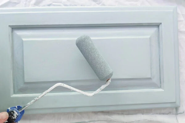 paint roller and cabinet door painted blue.