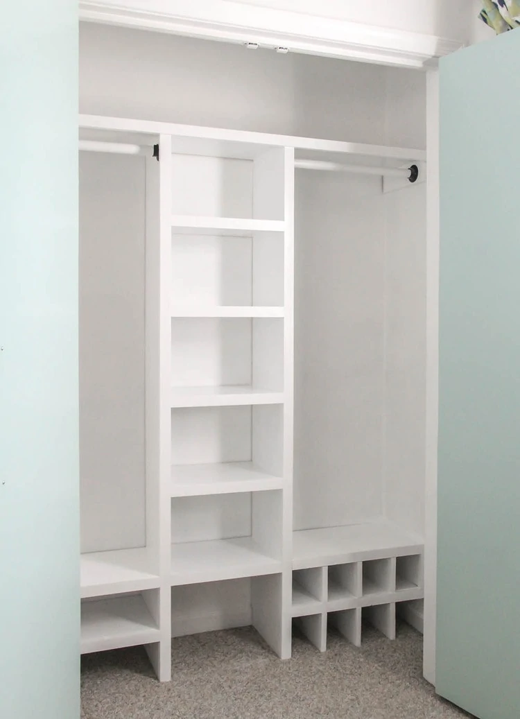 Finished DIY closet organizer with middle shelves, two hanging rods, and lots of shoe shelves.