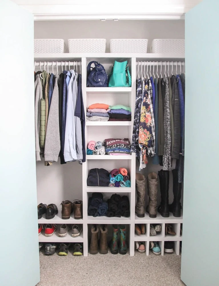 Finished DIY closet organizer filled with clothes, shoes, and accessories.