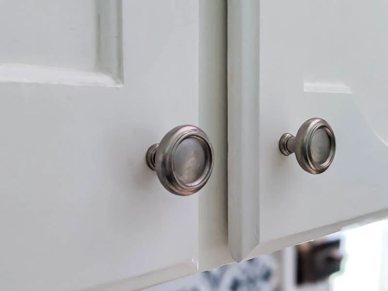 white kitchen cabinets painted super smooth using a paint roller and brush.