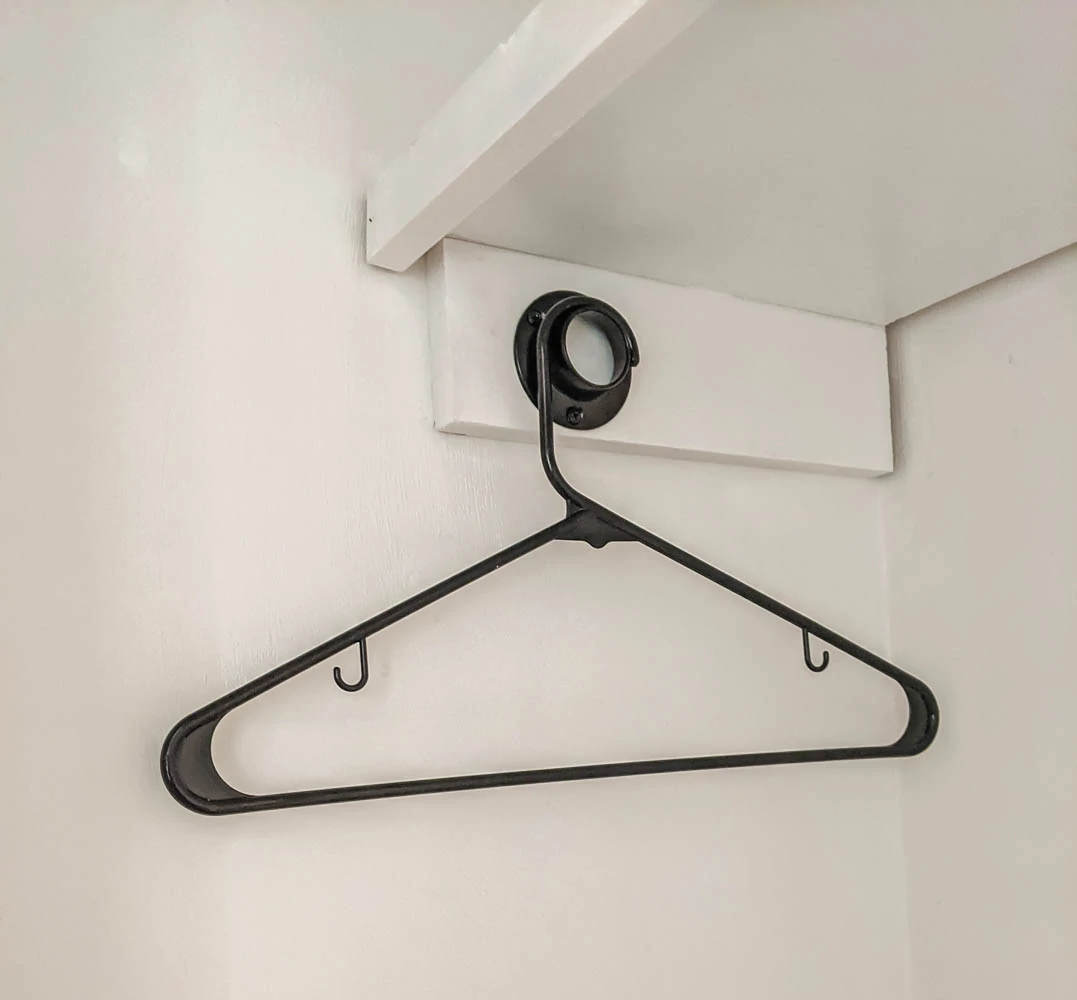 using a clothes hanger to measure the correct placement of the closet rod sockets.